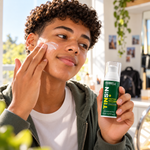 Teenage boy applying moisturiser to his cheek while holding Farrell Naturals Daily Face Moisturiser.