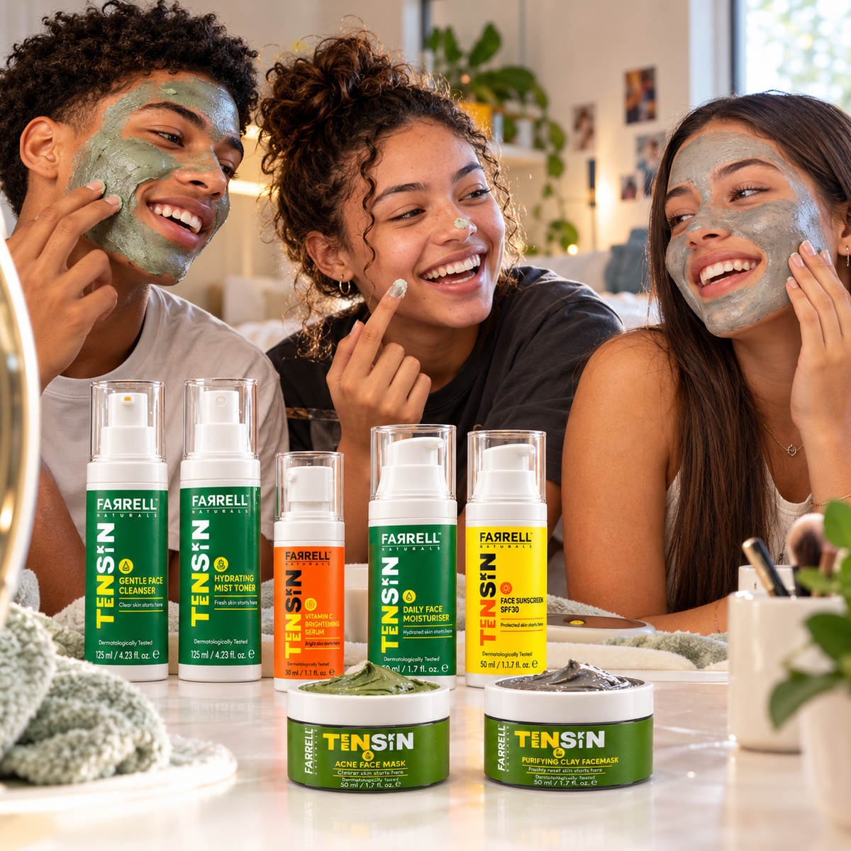 Three smiling teenagers enjoying skincare together with the complete Farrell Naturals TEENSKIN collection displayed in front of them.